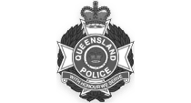 The image shows the Queensland Police badge, prominently featuring a crown at the top and "Queensland Police" in the central circle. A star framed by laurel leaves encases it, with the motto "With Honour We Serve" beneath—reflecting values also emphasized in work health and safety courses.